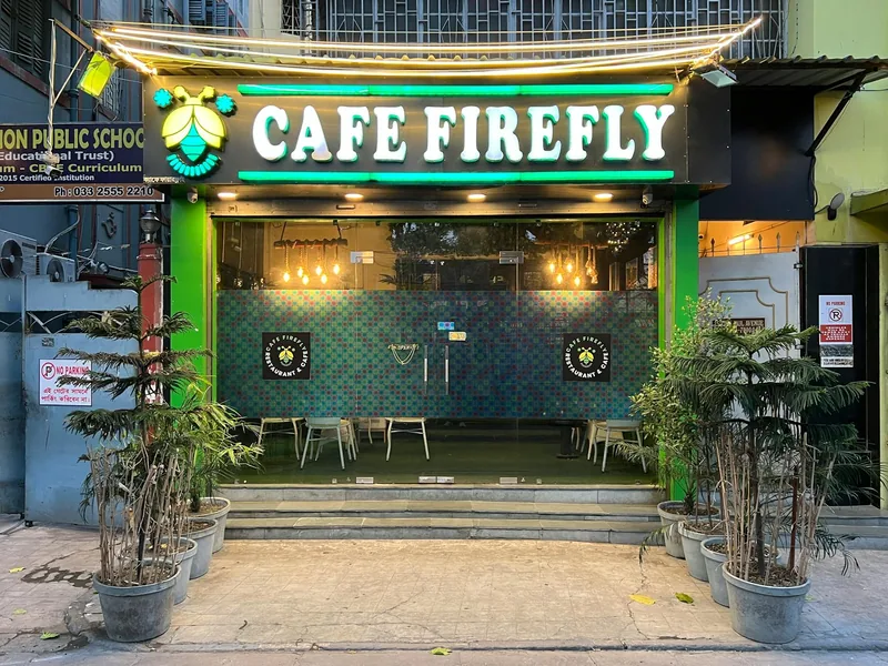 A warmly-lit Chaileela-style café storefront in the evening